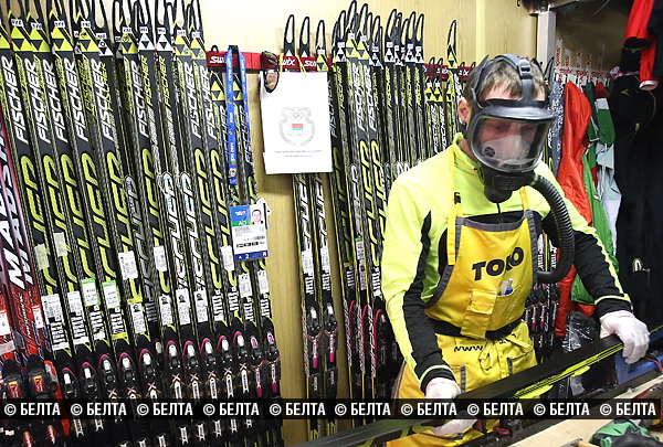 сервисмен готовит лыжи перед стартом